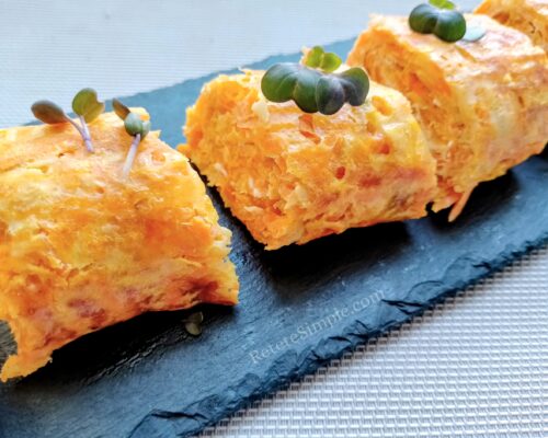Close-up of zucchini carrot roulade slice showing melted cheese inside