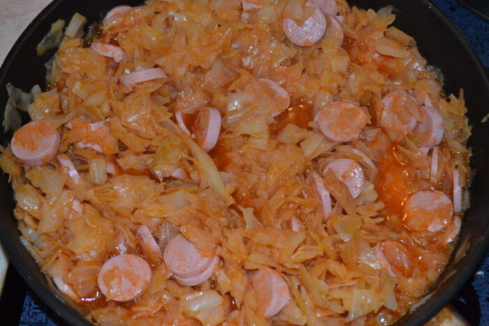 Adăugați cârnații în varza deja fiartă