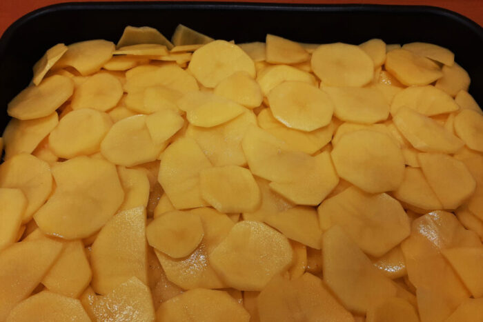 Después reparte una capa de patatas